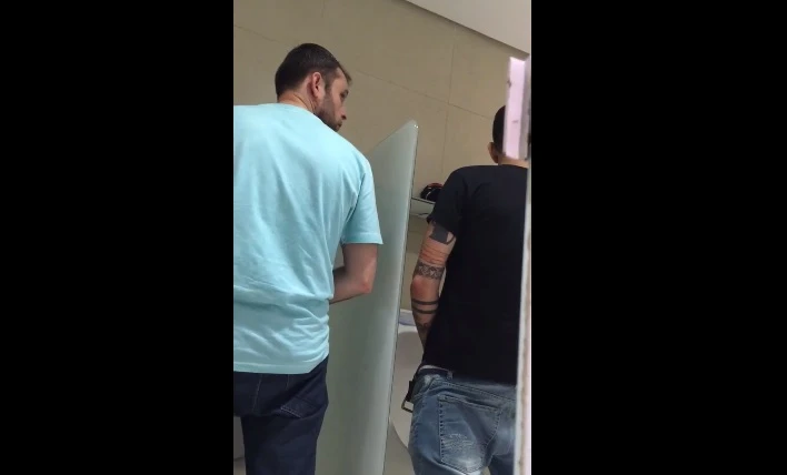 Machos batendo uma juntos no banheirão público