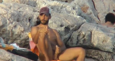 Macho bate punheta e goza no meio da praia de nudismo